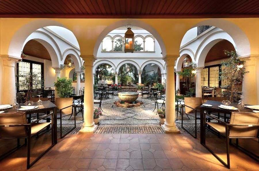 Patio andaluz con arcos y fuente central en Córdoba, plan con encanto en que ver en Córdoba en un dia.