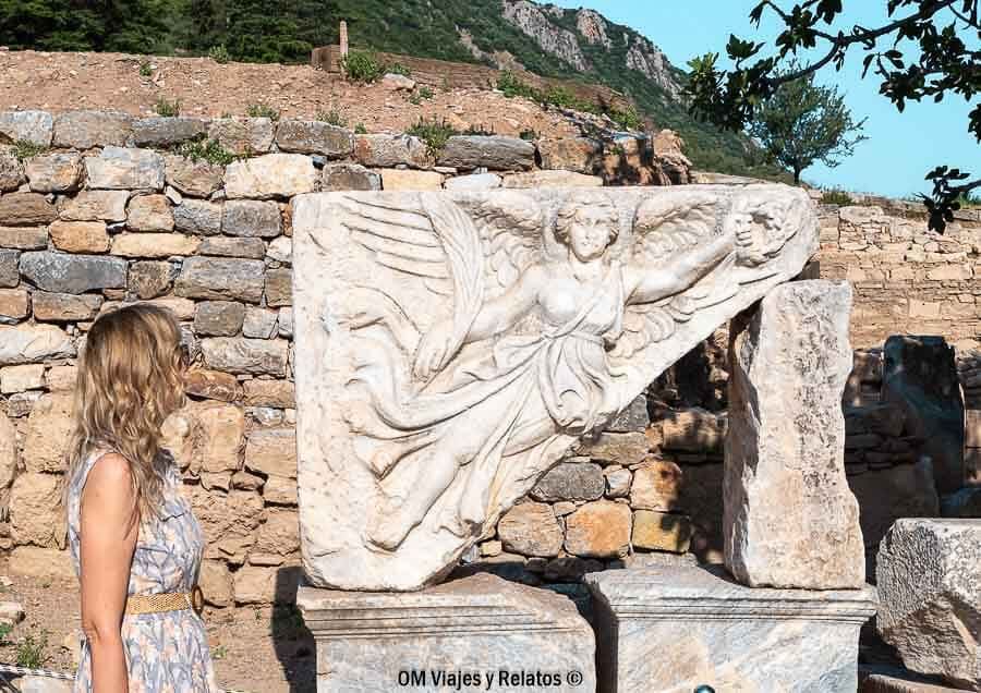 Foto mía observando un relieve de mármol con una figura alada (Nike/Victoria) en Éfeso, una curiosidad en que ver en Efeso.