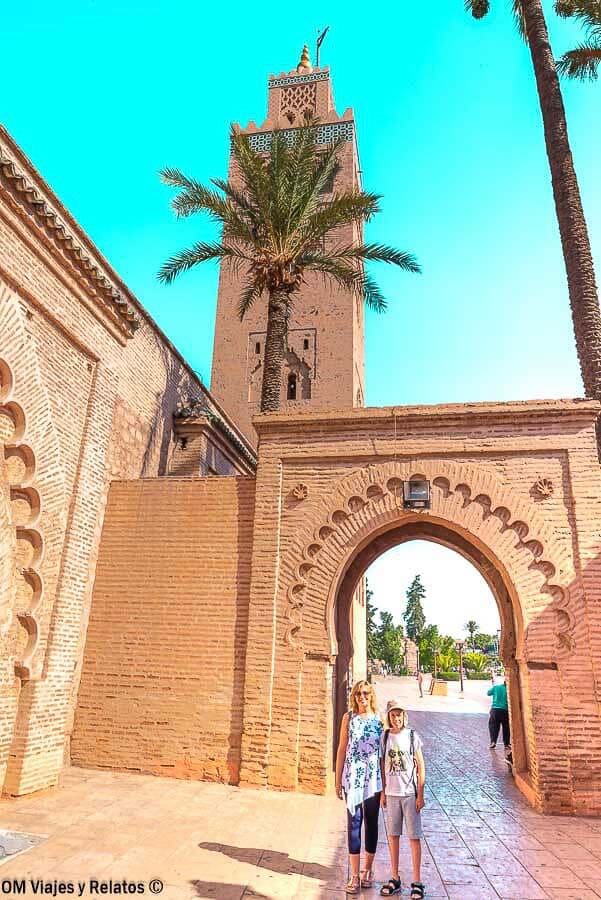Foto mía y de mi hijo bajo un arco con palmera y minarete en la medina, una parada clave de qué ver en Marrakech en 4 días.