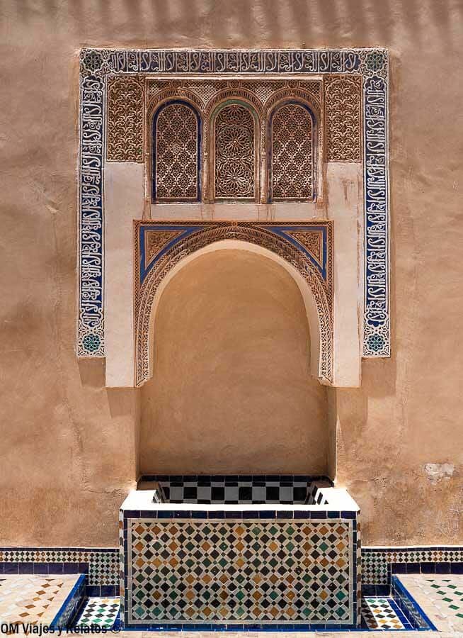Fuente con mosaicos y arco decorado con azulejos en un palacio de Marrakech, imprescindible en qué ver en Marrakech en 4 días.
