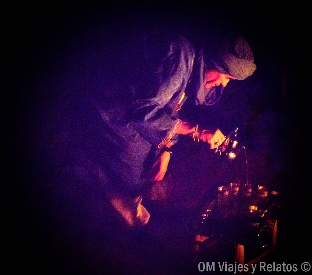 Beduino preparando té marroquí durante la noche en el desierto, en rutas en coche por Marruecos.