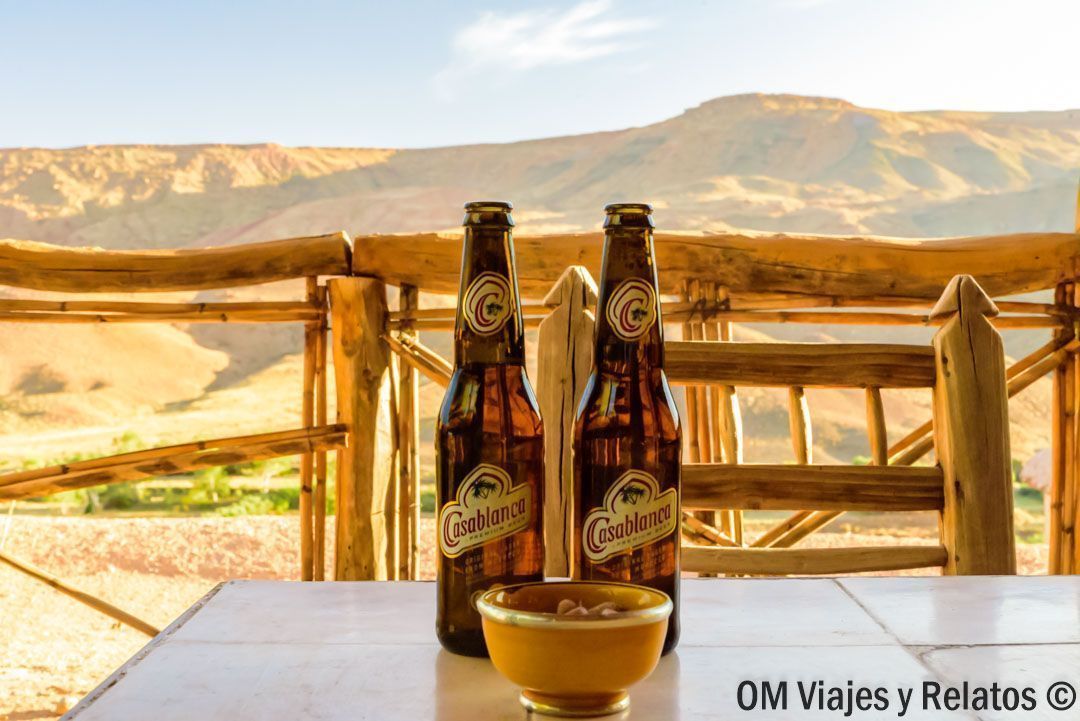 Cervezas marroquíes en una terraza con vistas a montañas y valle, plan perfecto para descansar en una ruta por Marruecos en coche.
