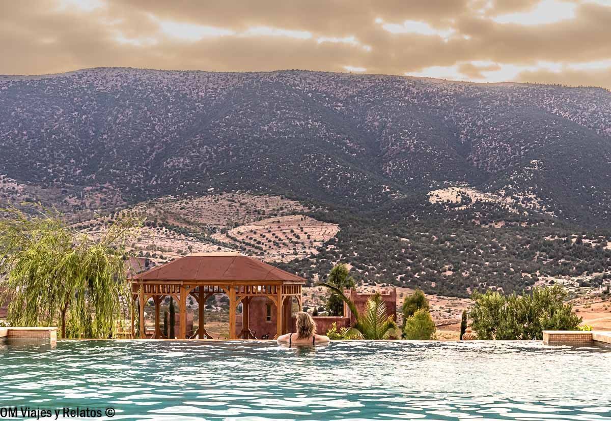 Servidora en la piscina del Hotel Palais d’Ouzoud con vistas a las montañas, un descanso ideal en rutas en coche por Marruecos.