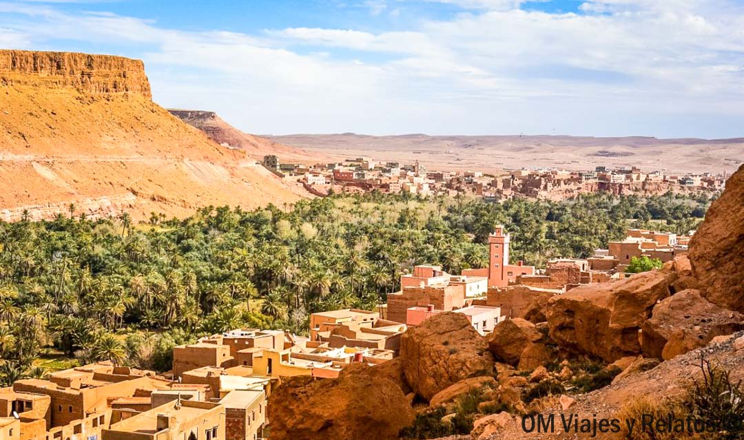 Valle con palmeral y pueblo de casas de adobe en el oasis marroquí, paisaje imprescindible en una ruta por Marruecos en coche.