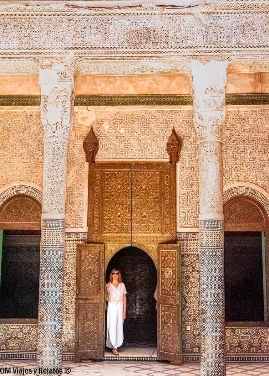 Servidora posando en un patio con mosaicos y columnas en Marrakech, parada cultural en una ruta por Marruecos en coche.