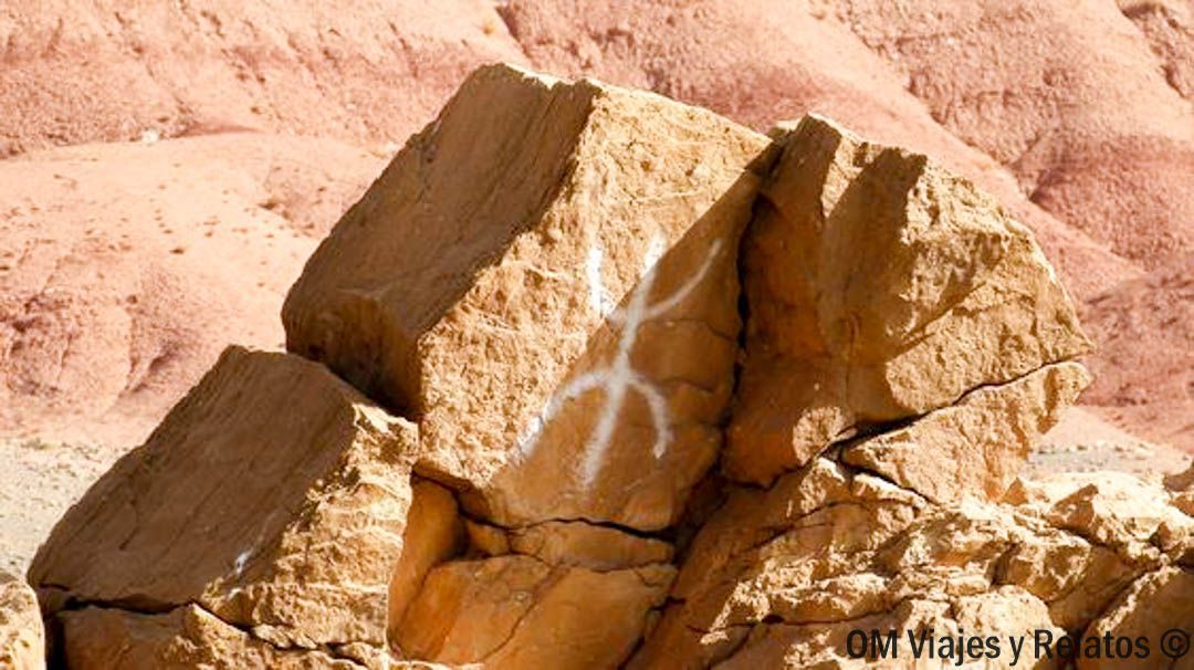 Rocas del desierto con grabado rupestre en piedra, parada cultural en las rutas en coche por Marruecos.
