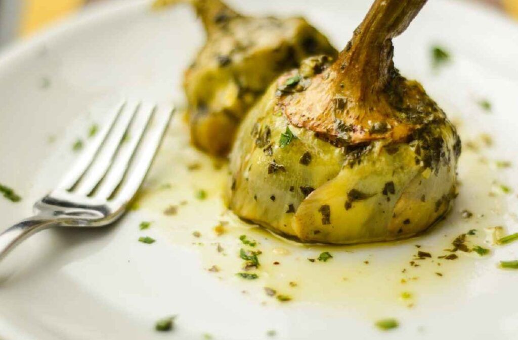 Alcachofa al estilo romano servida en un plato, una parada gastronómica en que ver en Roma en 4 días.