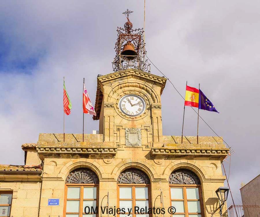 Ayuntamiento de piedra con reloj en la plaza mayor, una parada con encanto para descubrir rutas en Castilla y Leon.