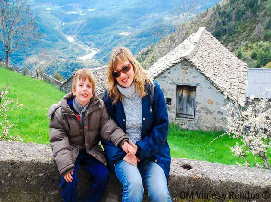 Foto mía y de mi hijo en un mirador con valle y cabaña de piedra, un plan familiar de que ver en Ordesa y Monte Perdido.