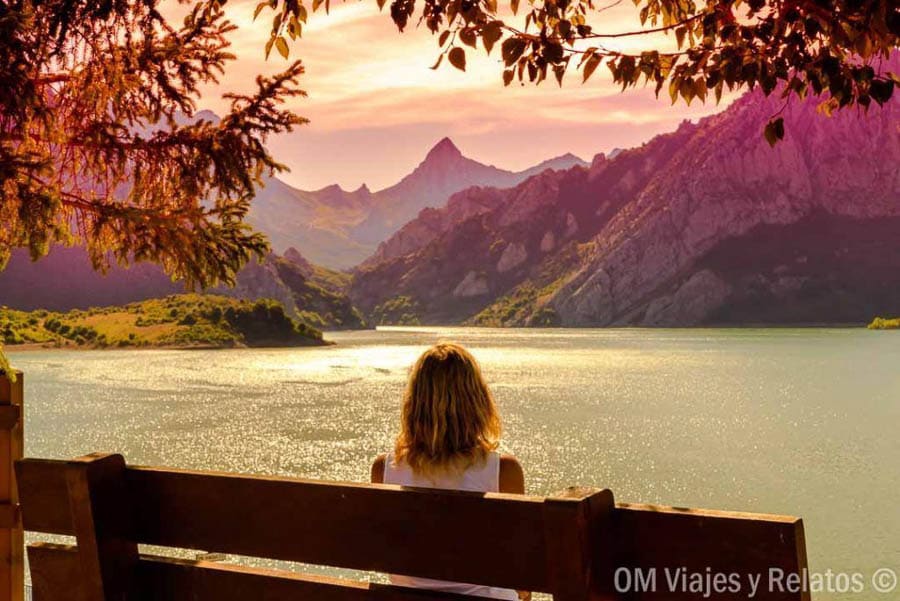 Una servidora contemplando el embalse de Riaño entre montañas al atardecer, una imagen inspiradora para descubrir rutas en Castilla y León.