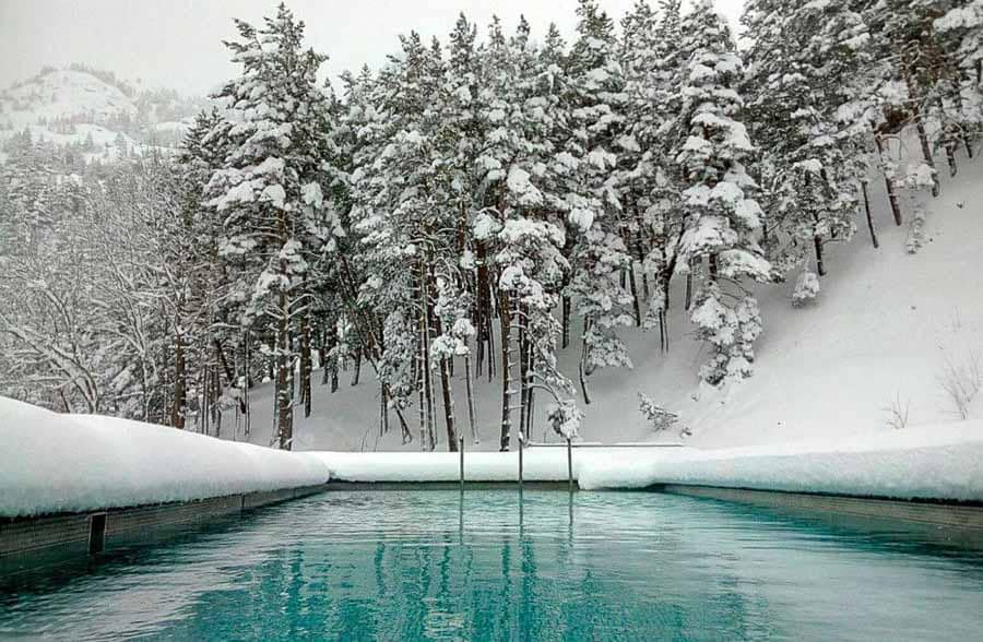 Piscina exterior del Balneario de Panticosa rodeada de nieve, un plan diferente de que ver en Ordesa y Monte Perdido.