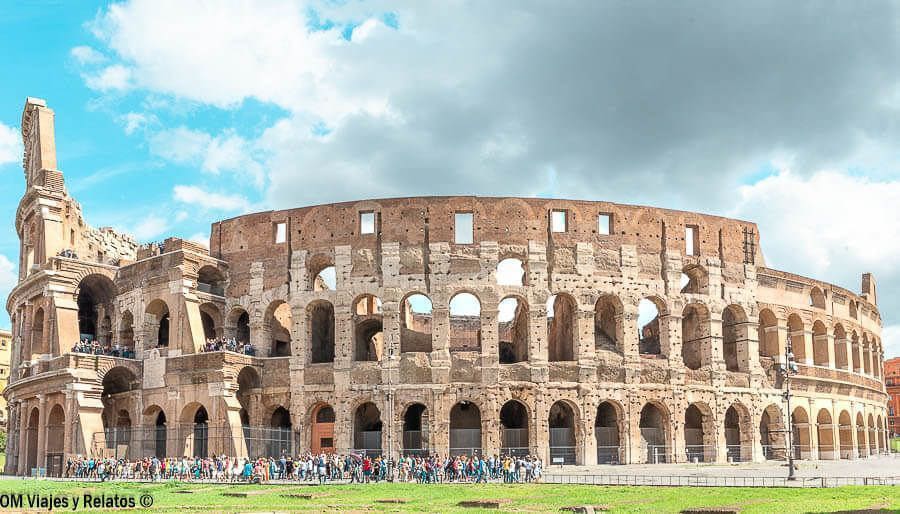 Vista exterior del Coliseo de Roma con visitantes y cielo azul, imprescindible en que ver en Roma en 4 días.