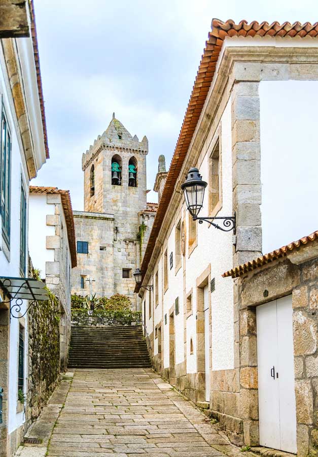 Calle del casco histórico de Baiona con escalinata y campanario de piedra, uno de los rincones con más encanto que ver en Baiona y alrededores.