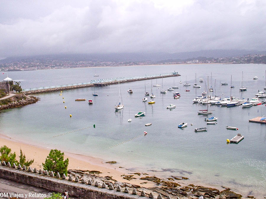 Puerto de Baiona con veleros fondeados y paseo marítimo, uno de los paisajes más bonitos que ver en Baiona y alrededores.