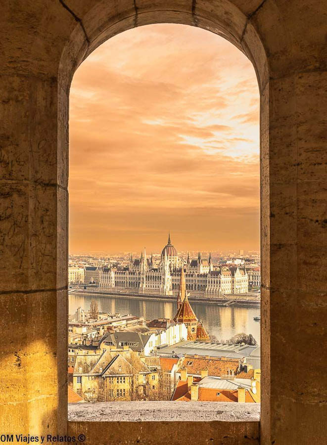 Parlamento de Budapest enmarcado desde el Bastión de los Pescadores al atardecer, una imagen imprescindible sobre que ver en Budapest en 3 días.