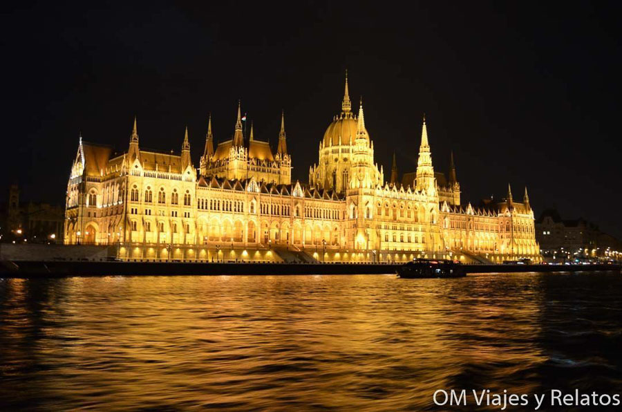 Parlamento de Budapest iluminado de noche junto al Danubio, una imagen imprescindible sobre que ver en Budapest en 3 días.