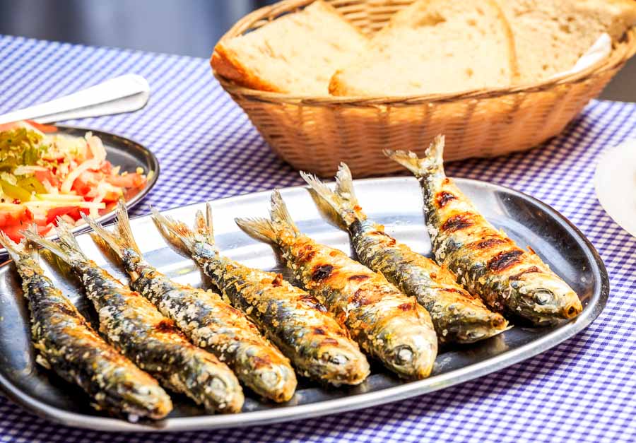 Sardinas a la brasa en un restaurante típico de Lisboa, una experiencia gastronómica que puede influir al elegir donde alojarse en Lisboa.