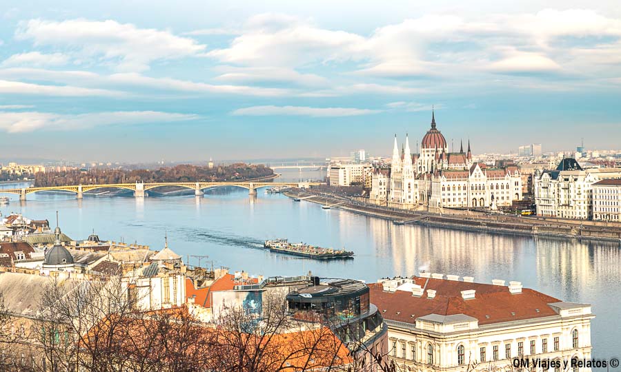 Vista panorámica del Danubio con el Parlamento de Budapest y un barco navegando, una de las imágenes más icónicas de un paseo en barco Budapest.