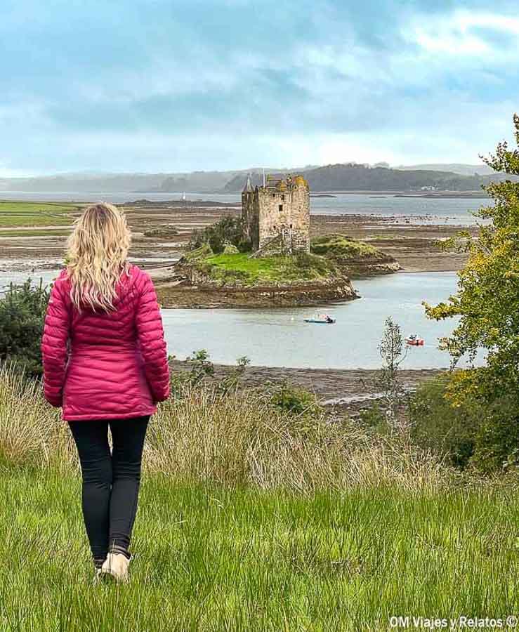 Foto mía contemplando el castillo de Castle Stalker en las Highlands de Escocia durante una ruta para que ver Escocia en 7 días.