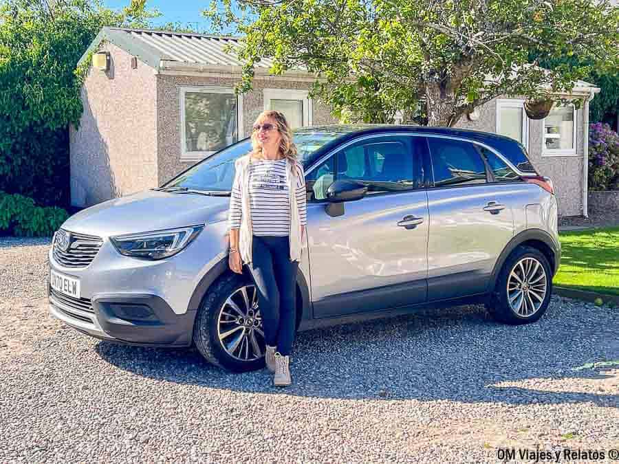Una servidora junto al coche de alquiler durante una ruta por carretera para ver Escocia en 7 dias por libre.