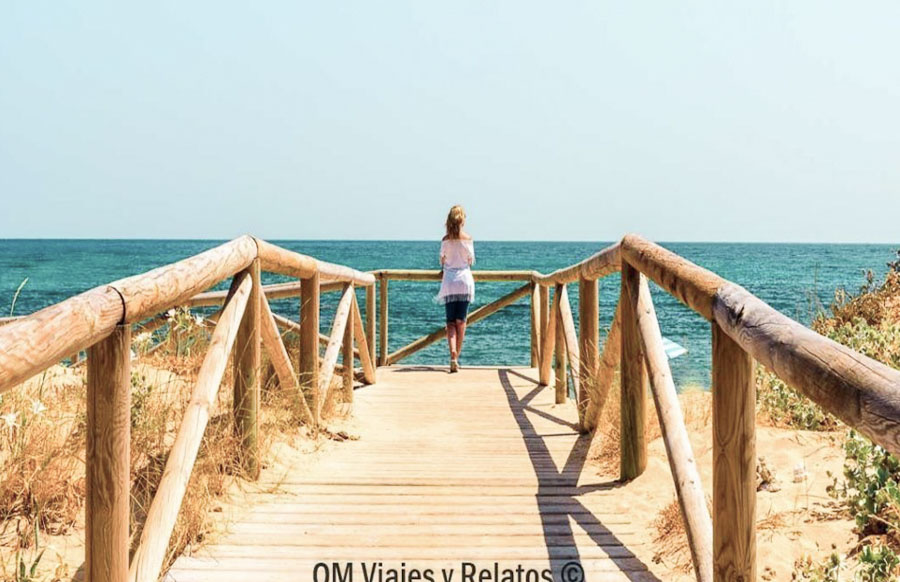 Pasarela de madera hacia una de las playas mas bonitas de Cádiz con vistas al mar azul.