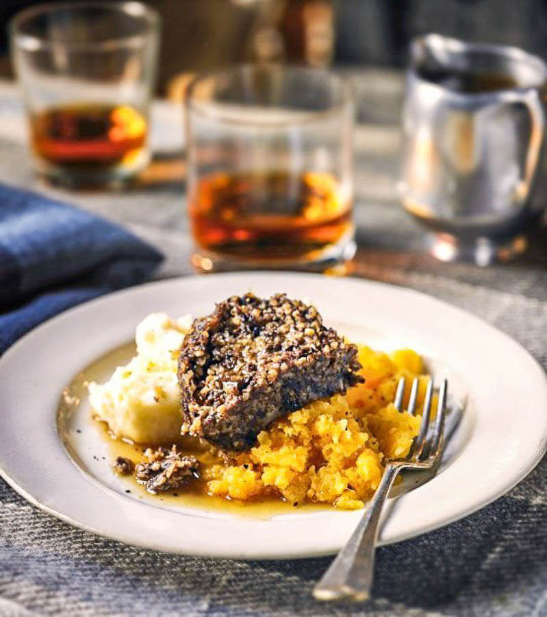 Plato típico escocés acompañado de whisky, una experiencia gastronómica que vivir en Escocia en 7 días.