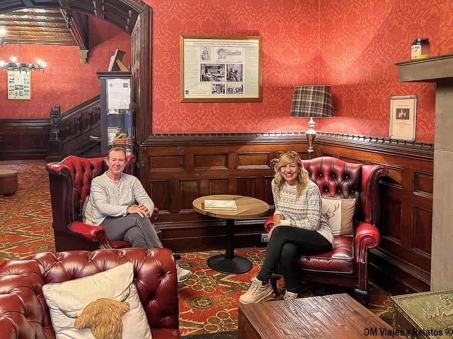 Una servidora con mi pareja descansando en el acogedor salón del Tulloch Castle durante su ruta sobre qué ver en Escocia en 7 días.