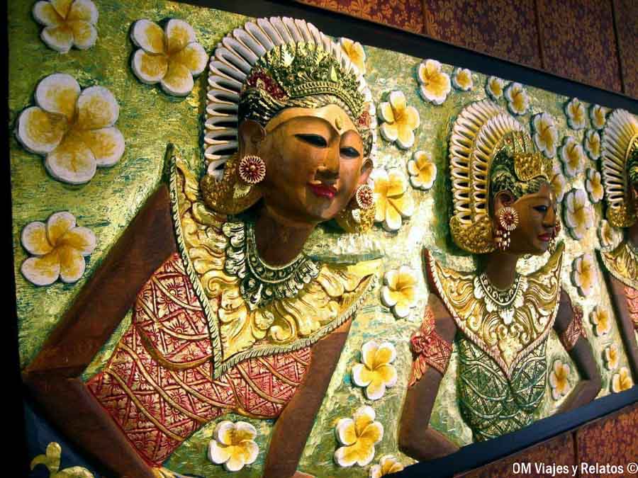 Relieve decorativo con figuras de danza balinesa y flores tropicales, una muestra de artesanía local para incluir al planificar qué ver y hacer en Bali por zonas.