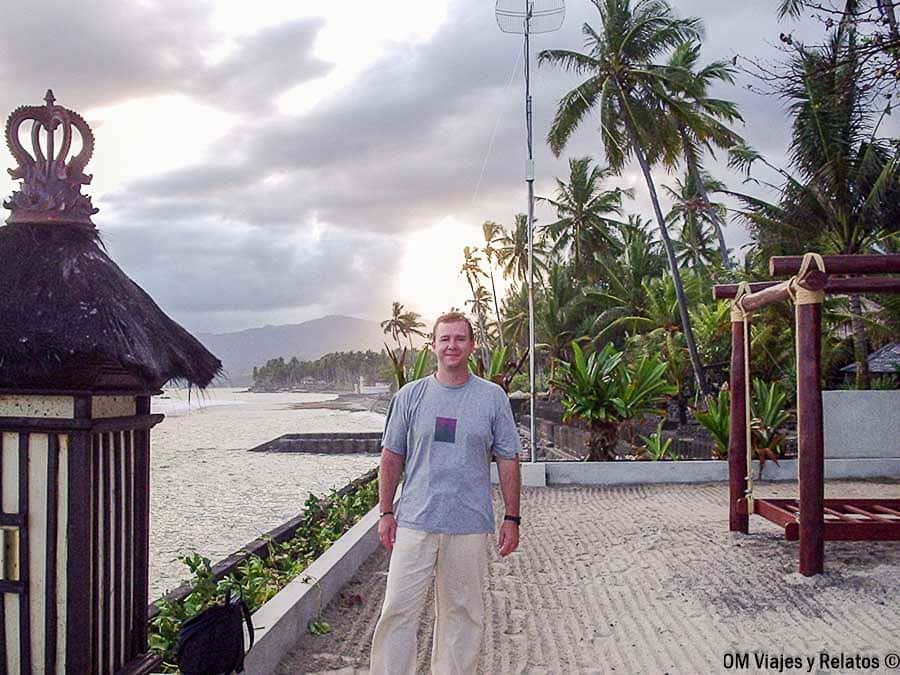 JC posando junto al mar en Candidasa, una zona tranquila de la costa este para incluir al planificar qué ver y hacer en Bali por zonas.