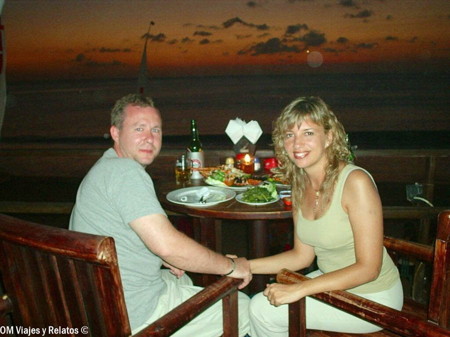 Foto en pareja de OM Viajes y Relatos cenando frente al mar al atardecer en Bali, un plan romántico para incluir al organizar qué ver y hacer en Bali por zonas.