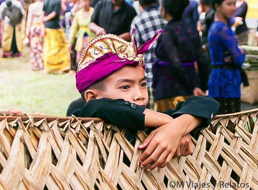 Niño con vestimenta tradicional durante una ceremonia de cremación balinesa, una experiencia cultural para entender qué ver y hacer en Bali por zonas.