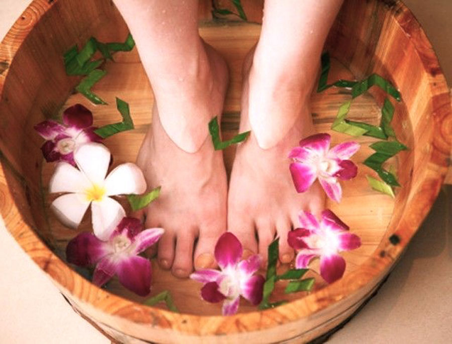 Baño de pies con flores tropicales antes de un masaje balinés, una experiencia relajante para incluir al planificar qué ver y hacer en Bali por zonas.
