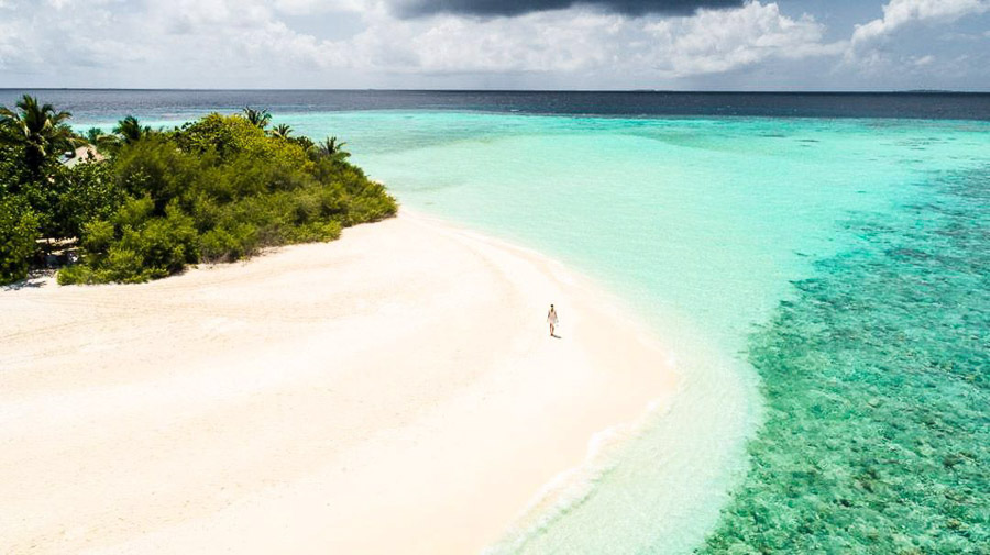 Vista aérea de la playa y laguna turquesa de Embudu Village Resort, una imagen inspiradora para decidir que hotel elegir en maldivas.
