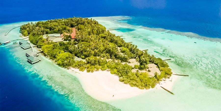 Vista aérea de Embudu Village Resort rodeado de laguna turquesa y arrecife, una imagen ideal para decidir que hotel elegir en maldivas.