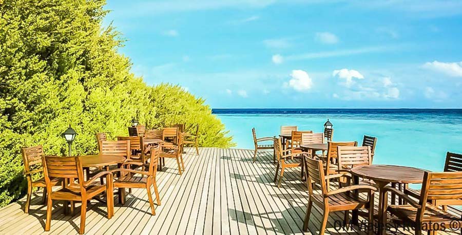 Terraza de restaurante frente al mar turquesa en Maldivas, una imagen útil para decidir que hotel elegir en maldivas.