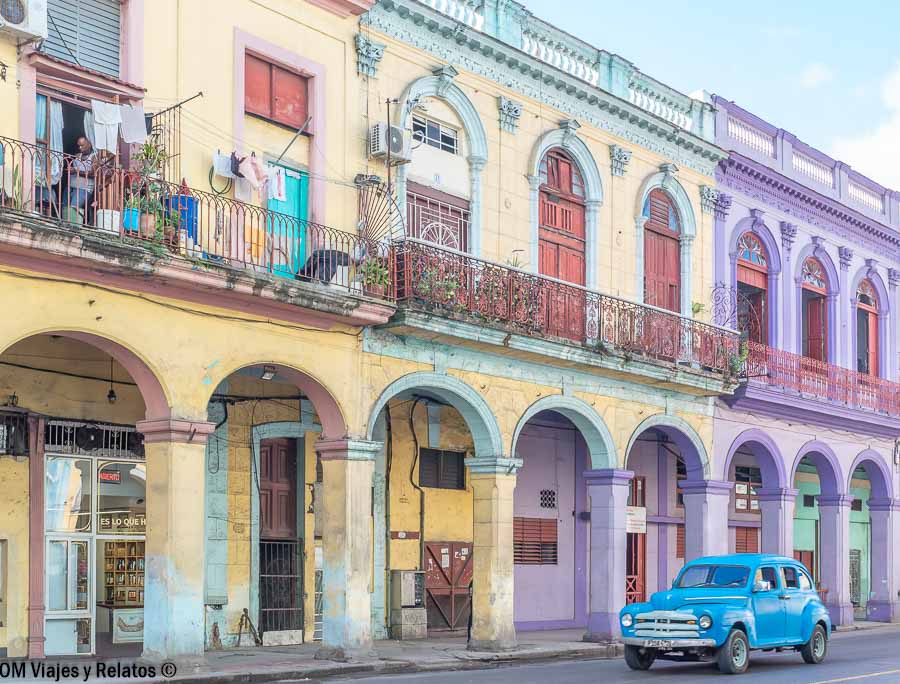 Fachadas coloniales de colores y coche clásico azul en La Habana, una imagen perfecta para inspirar que ver cerca de la Habana excursiones.