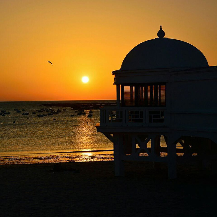 Atardecer en la Playa de La Caleta, uno de los lugares más mágicos que ver en Cádiz en un día y uno de los rincones más fotografiados de la ciudad.