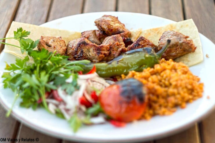 Plato de kebab turco del restaurante Palatium con arroz, verduras y pan, una parada gastronómica para incluir en que ver en Estambul en 3 dias.