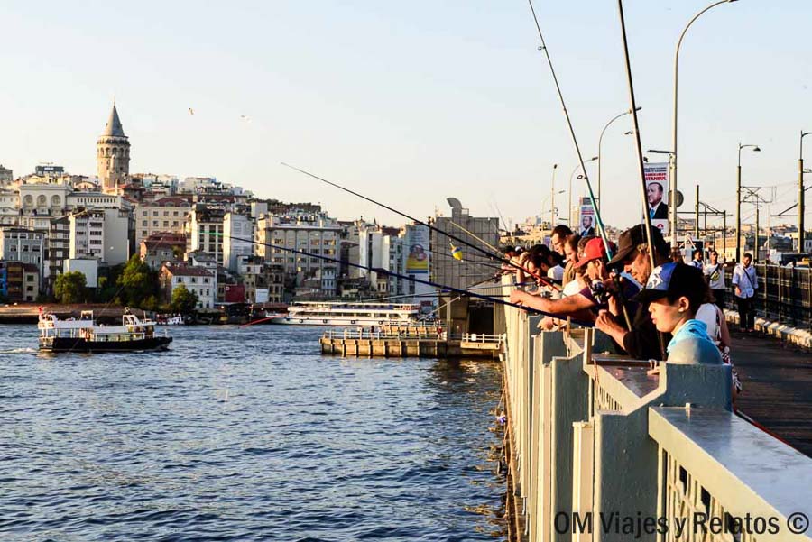 Pescadores en el puente de Gálata con la Torre de Gálata al fondo, una escena auténtica para incluir en que ver en Estambul en 3 dias.