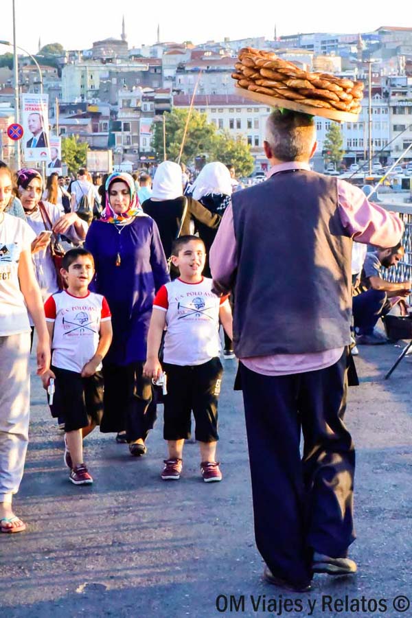 Vendedor de simit en el puente de Gálata entre el ambiente local de Estambul, una escena cotidiana para incluir en que ver en Estambul en 3 días.