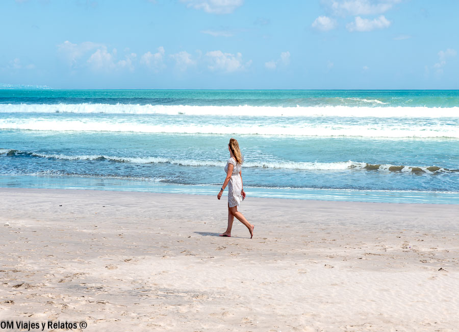 Foto mía paseando junto al mar en Jimbaran Beach, una playa de arena clara y aguas azules entre las mejores playas de Bali.