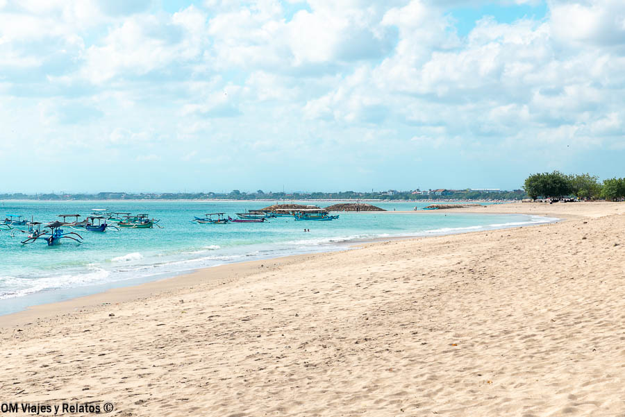 Vista de la Playa de los Alemanes en Bali, con arena clara, agua turquesa y barcas tradicionales, una de las mejores playas de Bali.