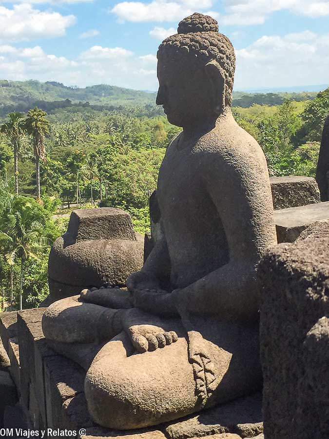 Estatua de Buda en Borobudur con el paisaje tropical de Java al fondo