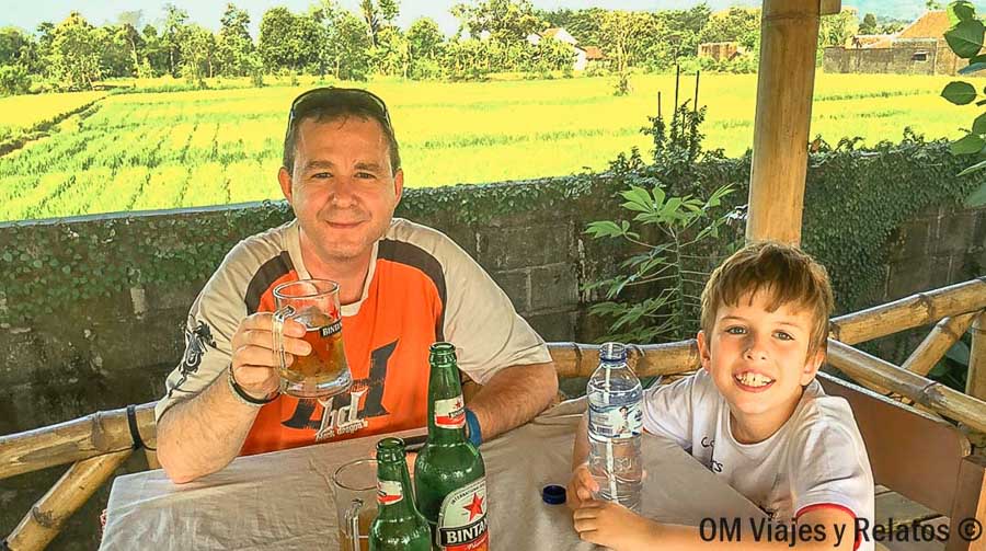 JC con nuestro hijo durante una parada para comer frente a los arrozales de Java