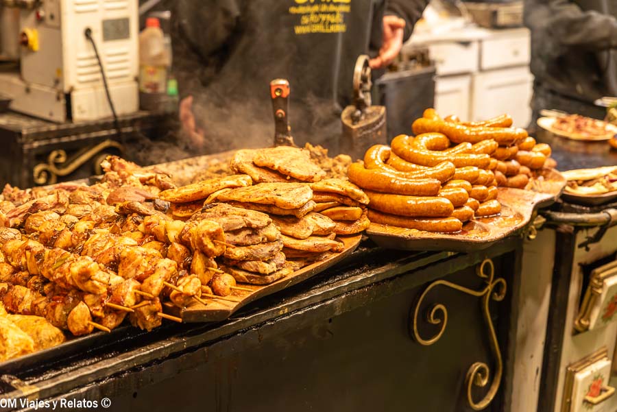 Salchichas y carnes asadas en un puesto de comida de un mercado navideño de Budapest
