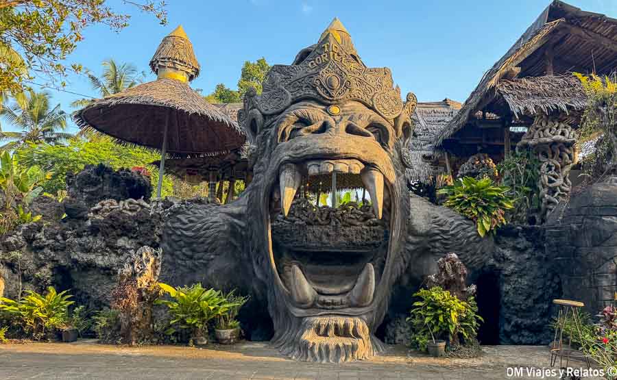 Entrada decorada con una gran escultura de gorila y arquitectura tradicional en Bali