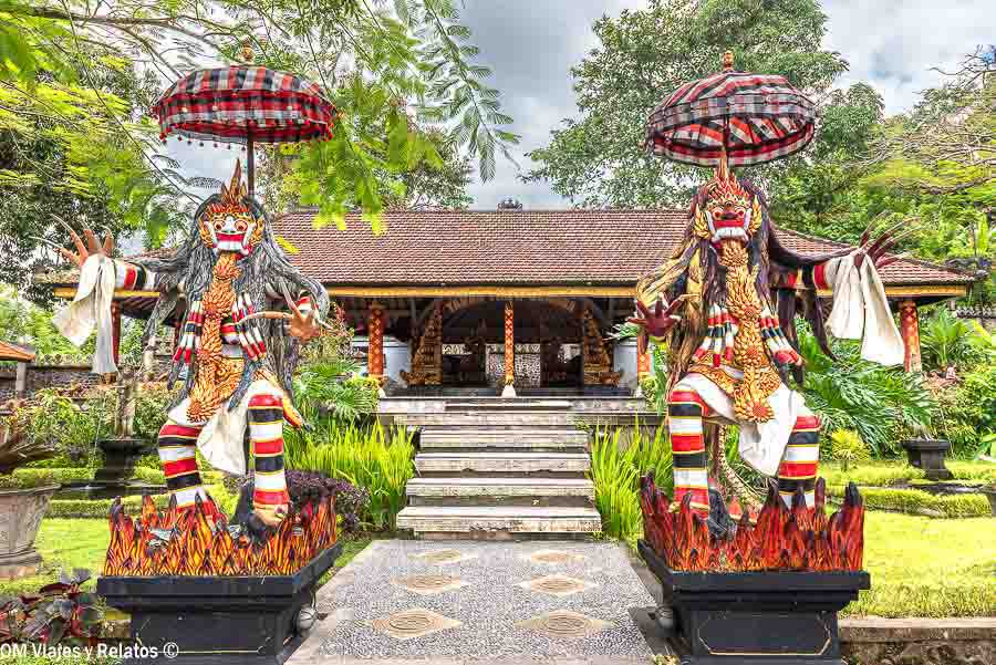 Esculturas tradicionales balinesas bajo sombrillas ceremoniales en un templo de Bali