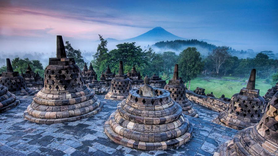 Estupas de Borobudur al amanecer con el volcán de Java al fondo