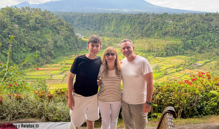 Foto familiar de OM Viajes y Relatos con arrozales y montañas de Bali al fondo