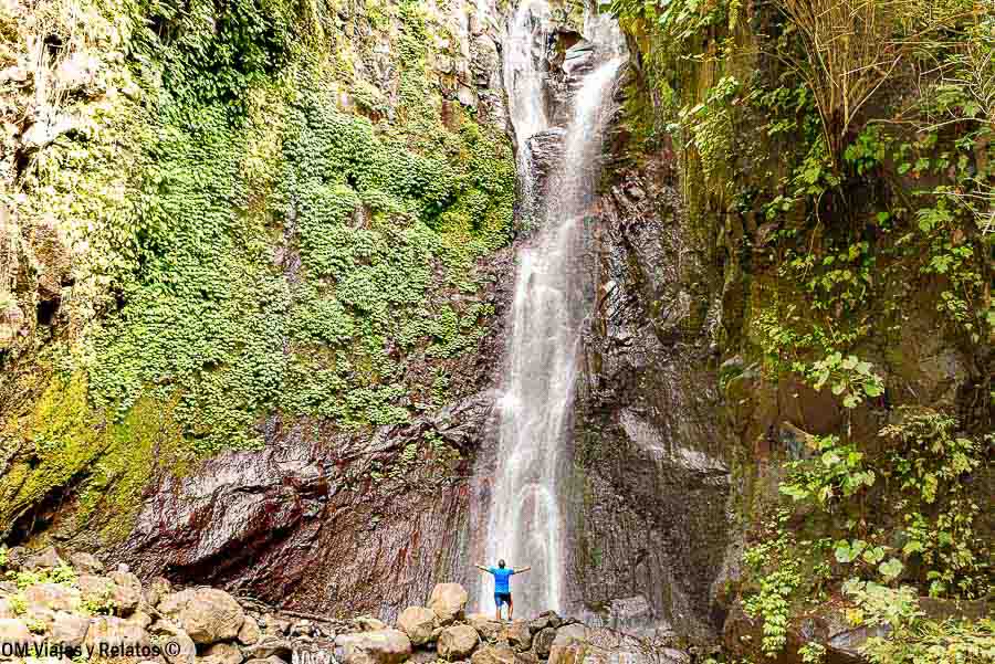 JC al pie de una gran cascada rodeada de vegetación durante nuestra ruta por Bali en 10 días